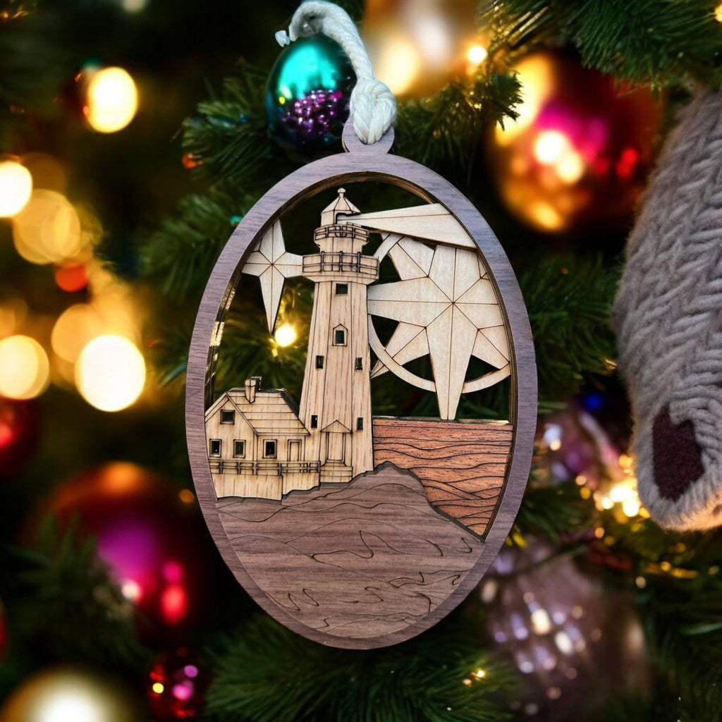 Decorative ornament with lighthouse and compass design on a Christmas tree.