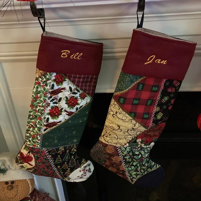 Two Christmas stockings with personalized names hanging on a fireplace.