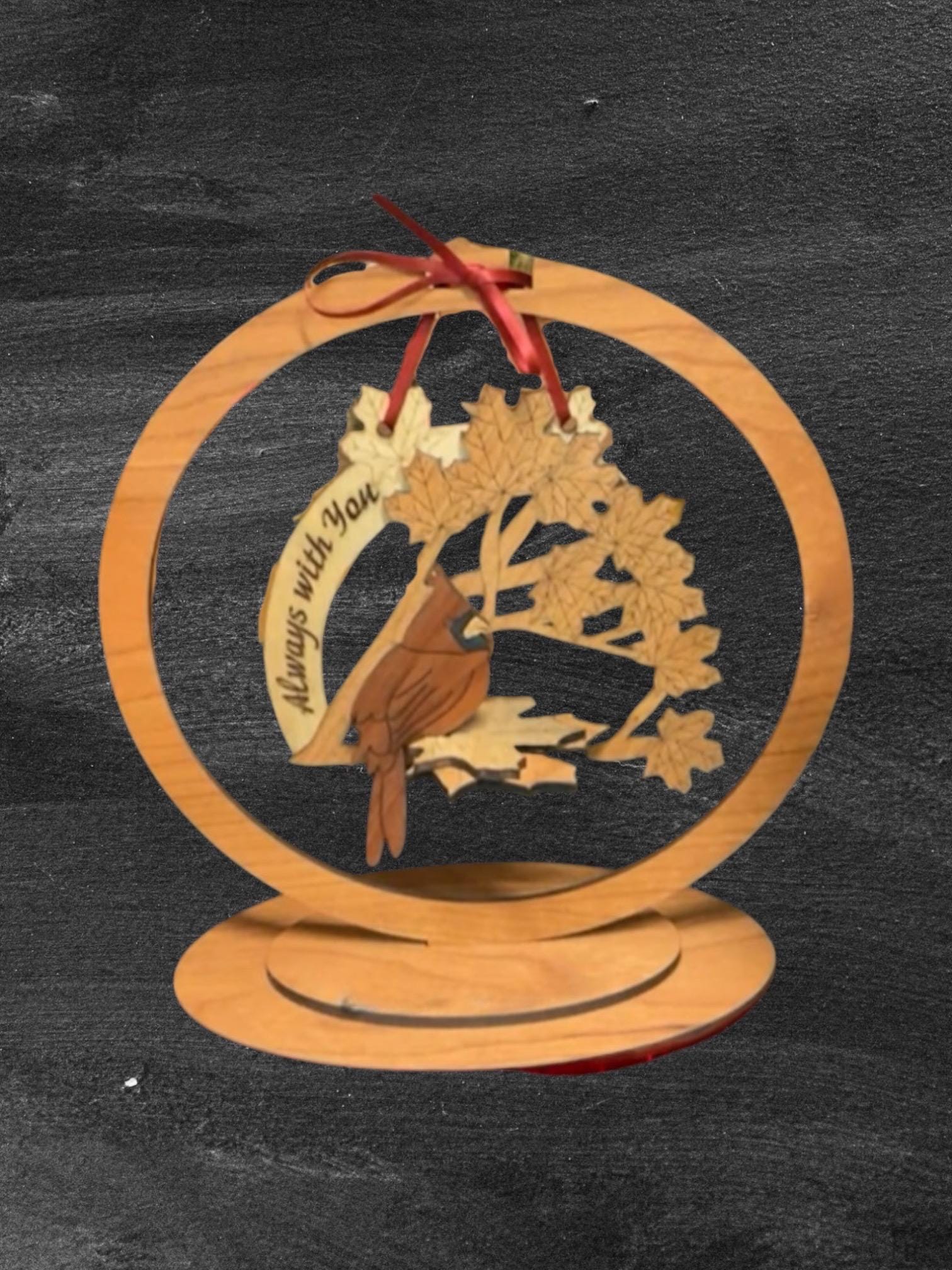 Wooden ornament with a bird design and 'Always with You' text on a dark background