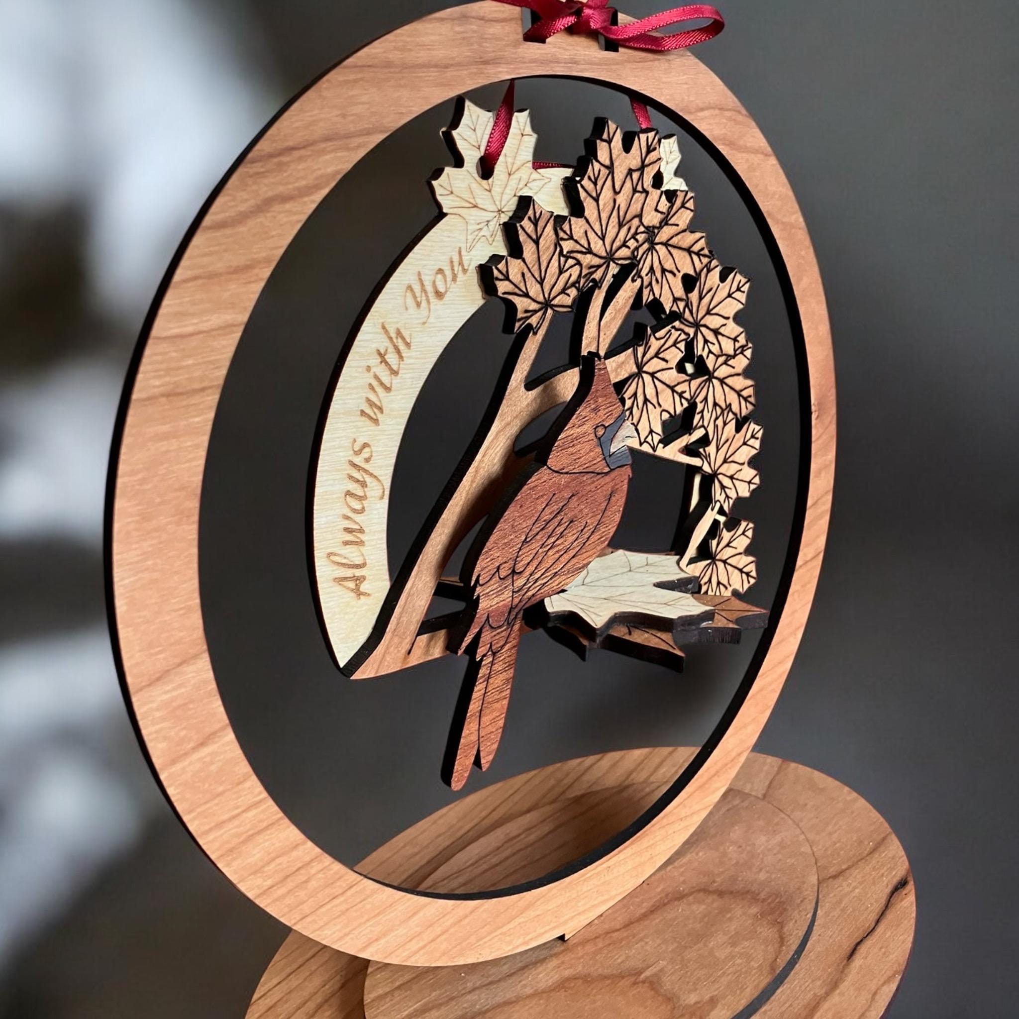 Close-up of layered wood design featuring a cardinal and leaves