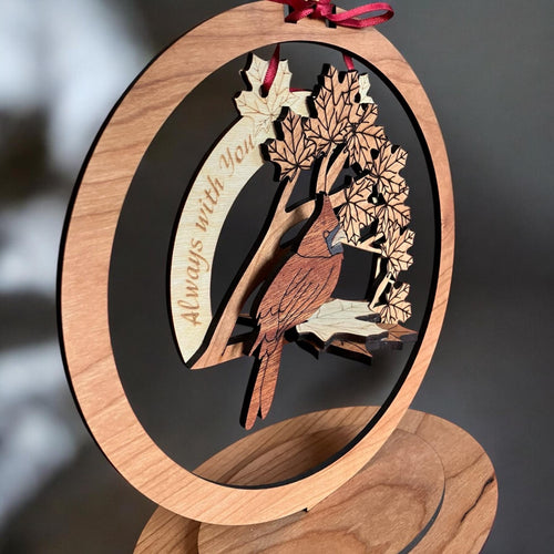 Close-up of layered wood design featuring a cardinal and leaves