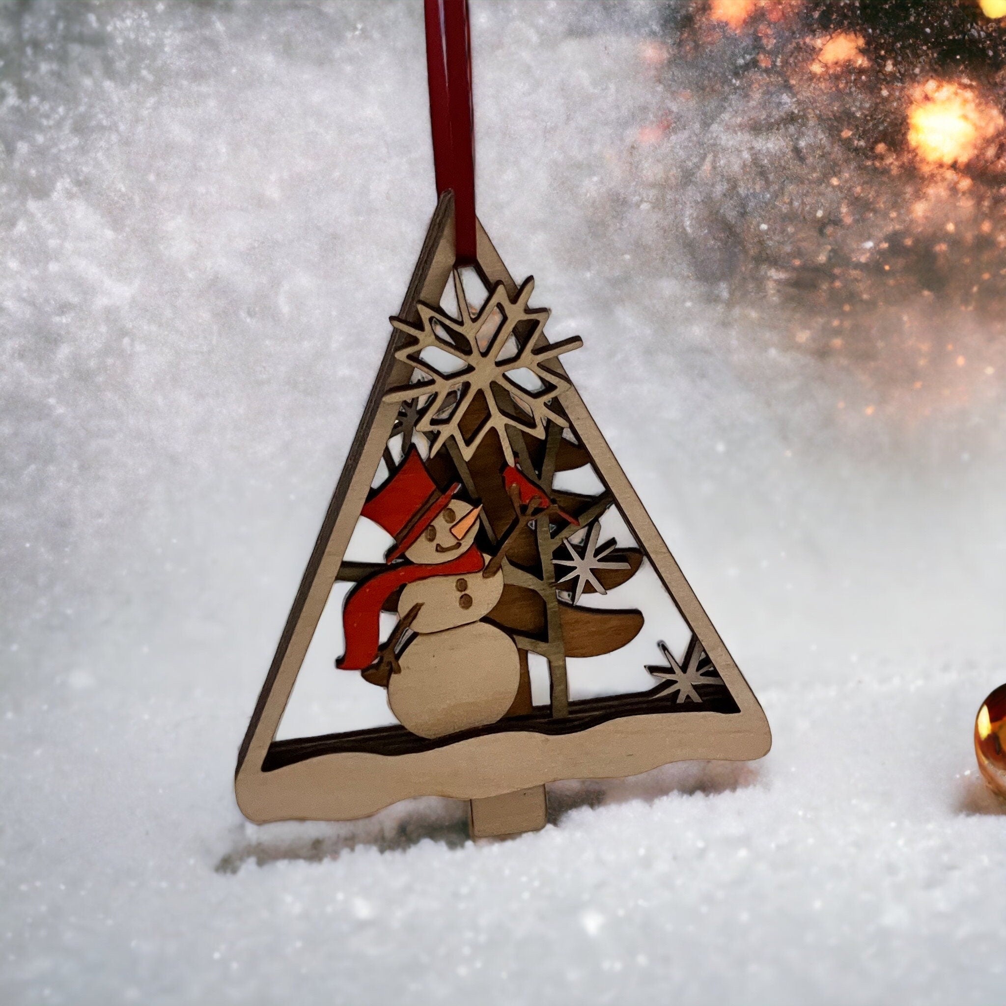 Wooden Christmas ornament with a snowman design on a snowy background