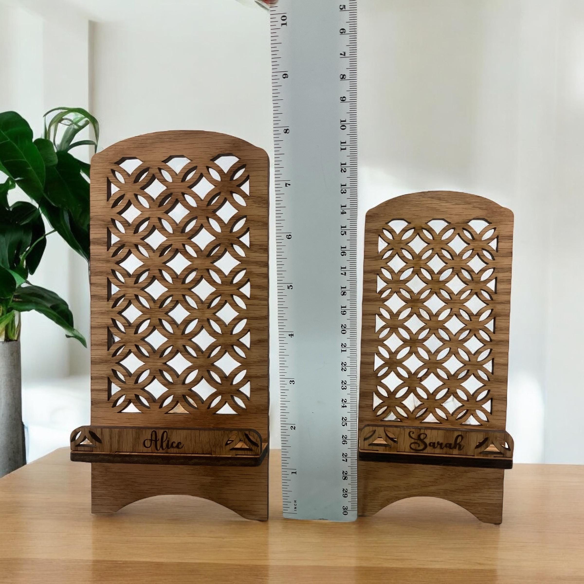 Two wooden decorative phone stands with lattice patterns and engraved names, next to a ruler for scale.