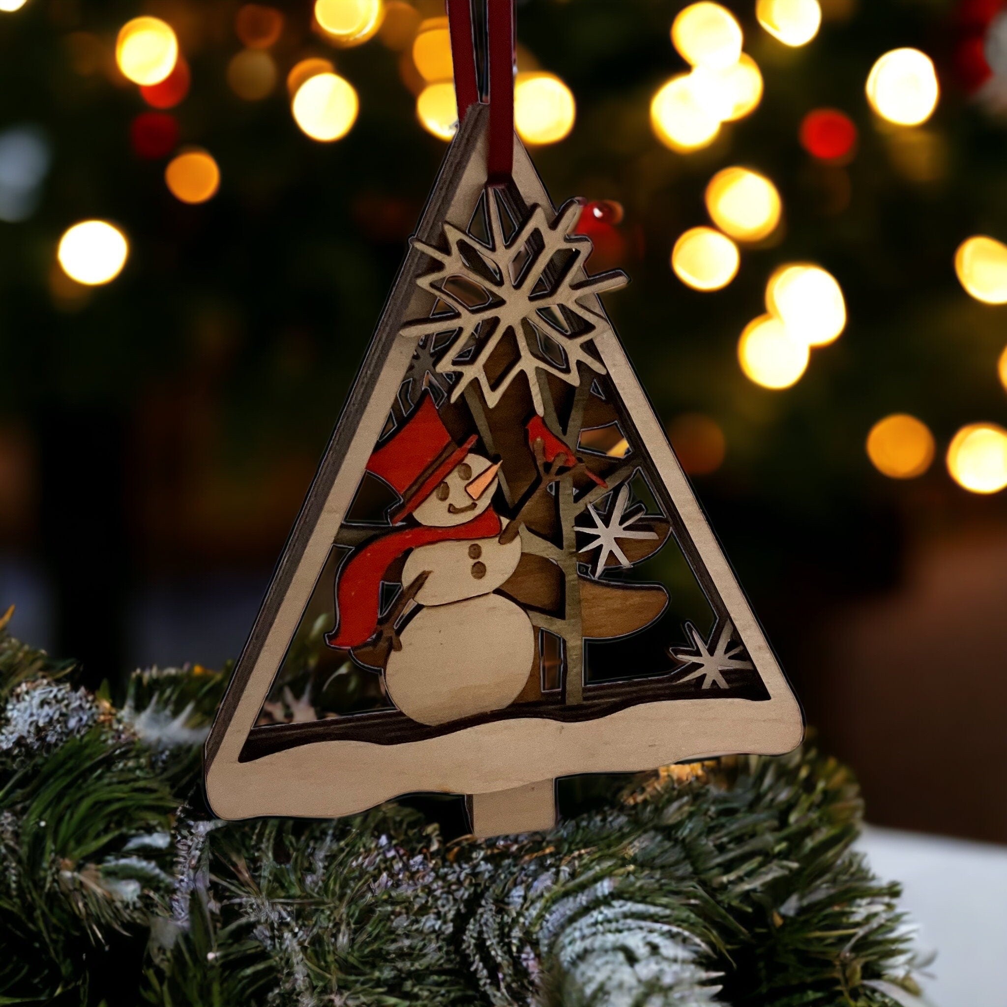 Wooden Christmas ornament with snowman design on a tree against a blurred festive background