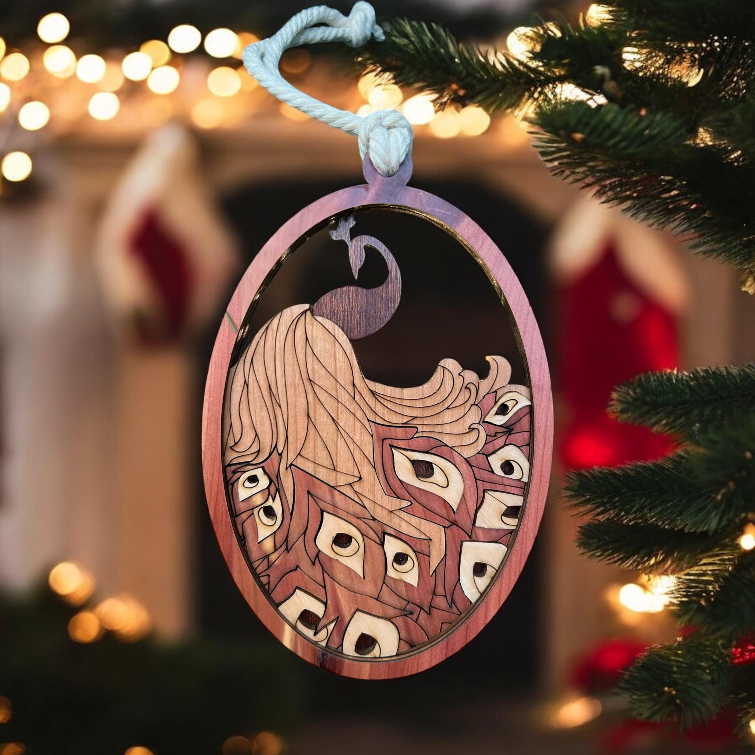 Laser-cut wooden peacock ornament hanging on Christmas tree
