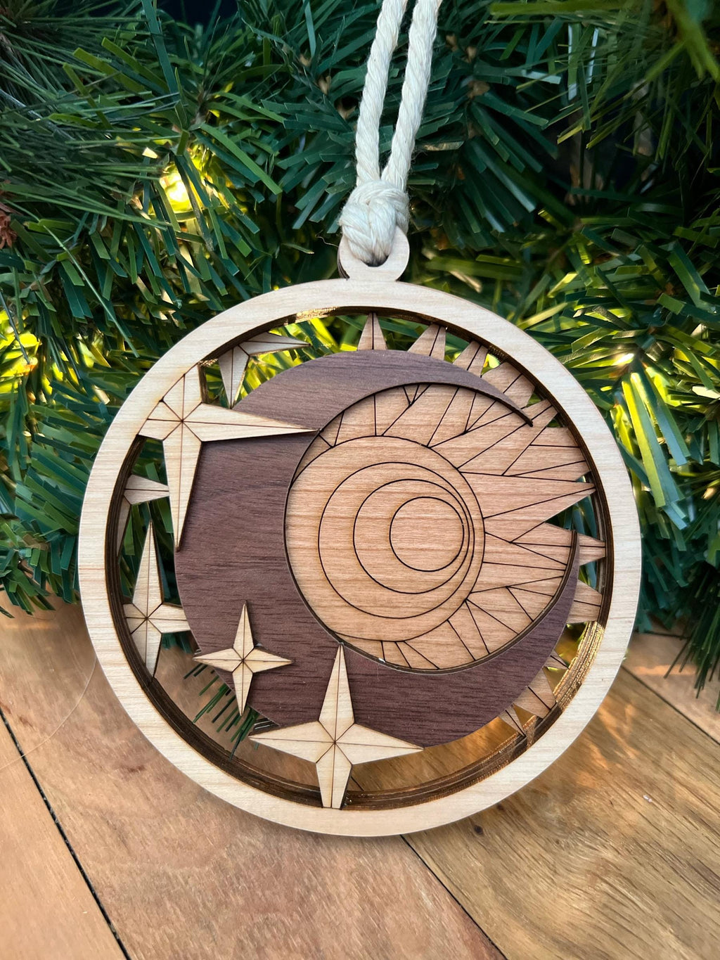 Wooden ornament with celestial design on a Christmas tree.