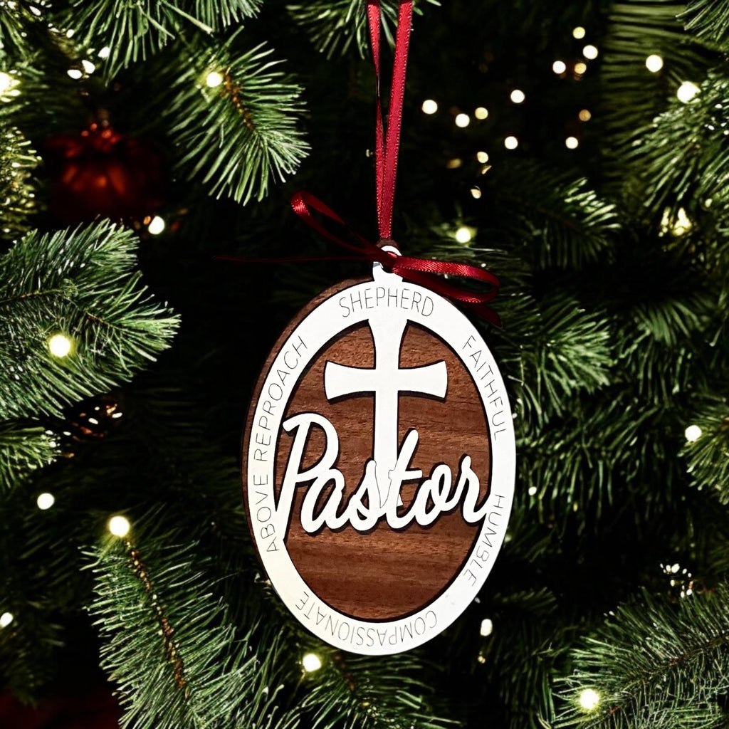 Ornament with 'Pastor' and cross design on a Christmas tree.