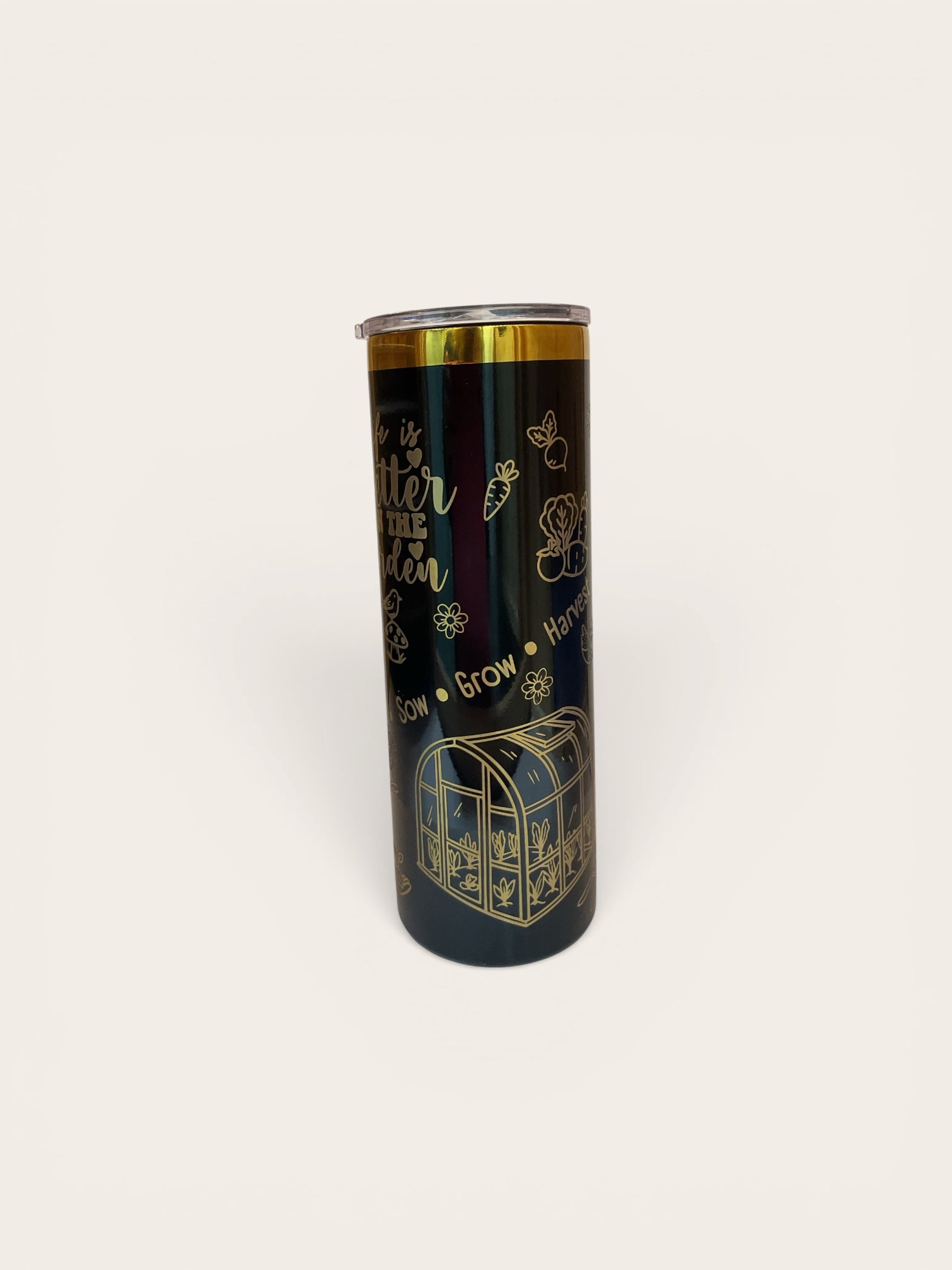 Black tumbler with gold text and designs on a white background
