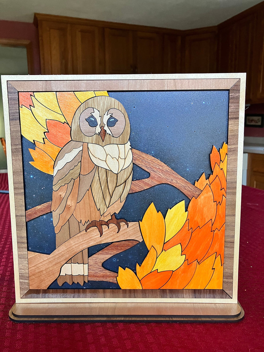 aser-cut wooden owl figurine with starry background