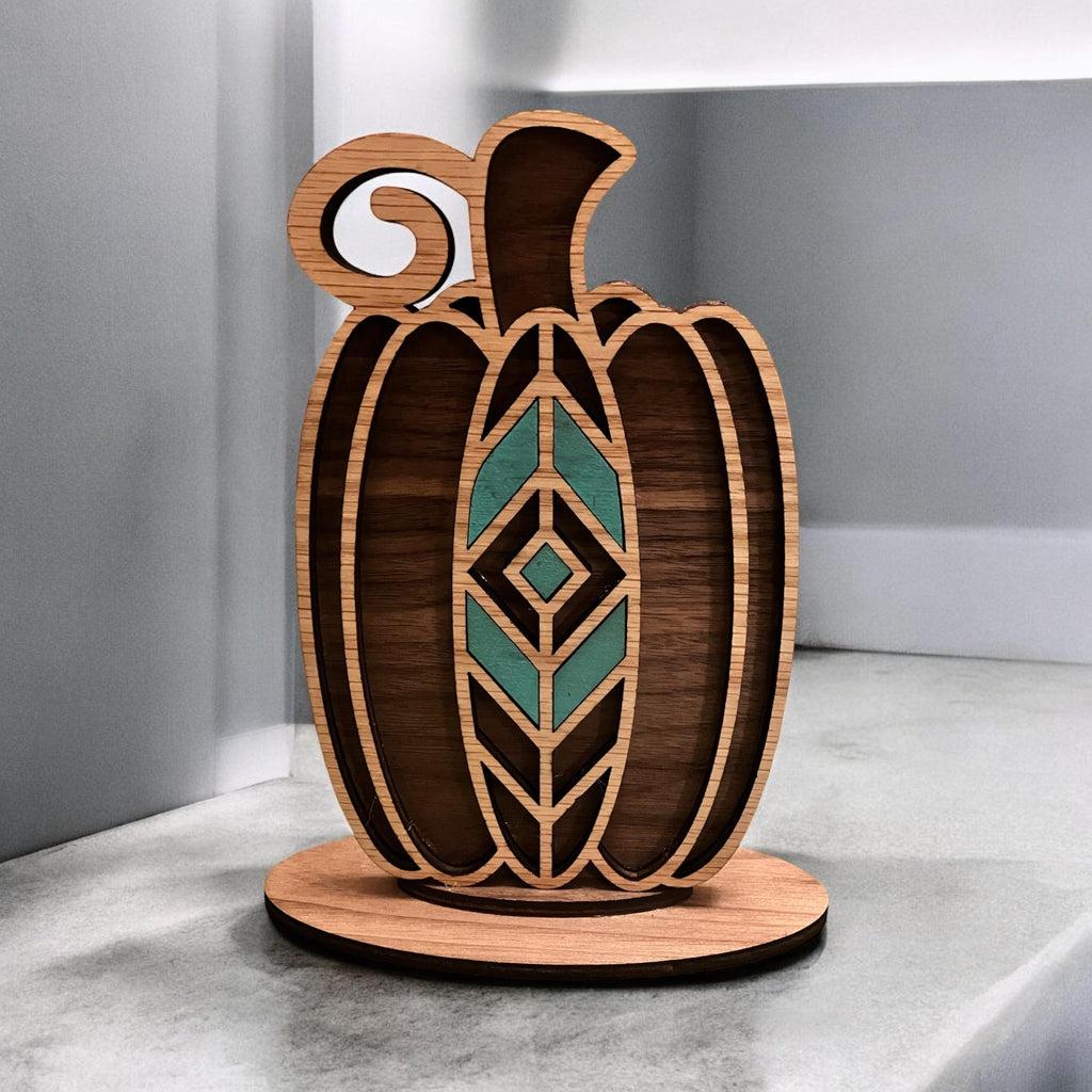 Laser-cut geometric wooden pumpkin décor with teal or orange inlay on round base