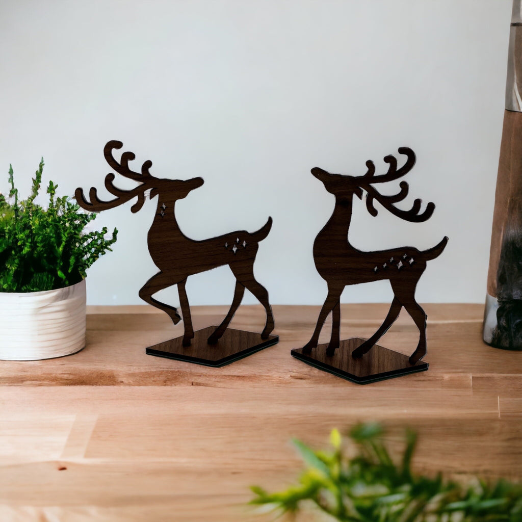 Two wooden deer figurines on a wooden surface 