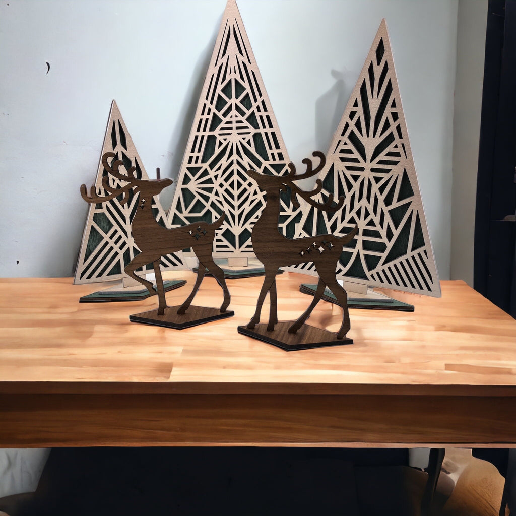 Wooden deer figurines and geometric tree decorations on a wooden surface.